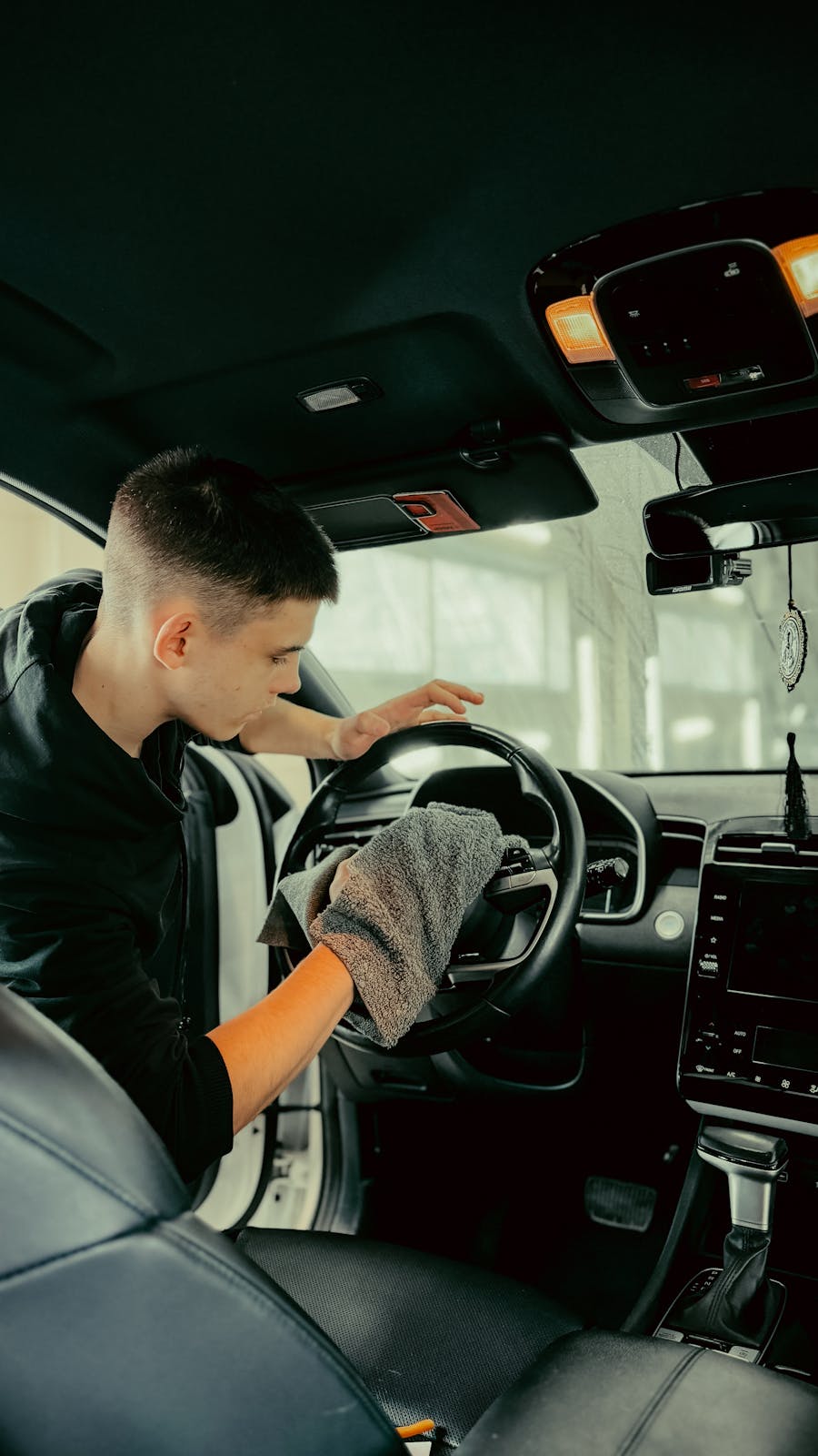 Dashboard and trim area being cleaned inside a car