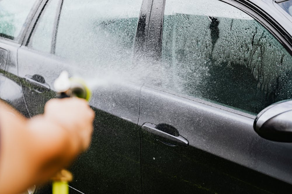 Car exterior being washed as part of recurring maintenance care
